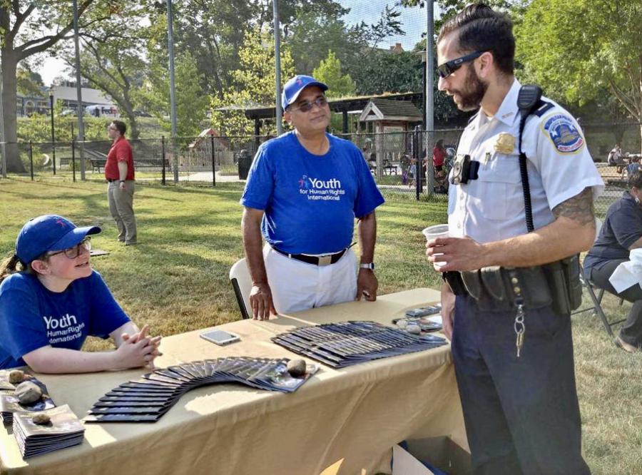 Volunteers discussing with DC Police Captain how human rights education can be used as a tool to combat human trafficking.
