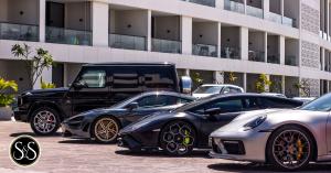 Luxury cars in a row from closest to farthest; Porsche, Lamborghini, McLaren, and Mercedes-Benz G-Wagon