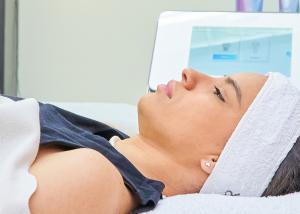 Woman with a headband lying down on a bed at a med spa.