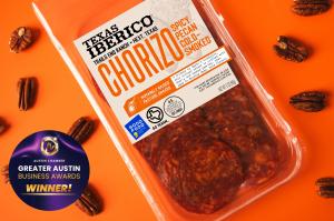 Package of Texas Iberico Spicy Pecan Cold-Smoked Chorizo on an orange background with pecans and a Greater Austin Business Award Winner badge.