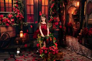 Girl posing in a rose-themed portrait setup created with a Kate Theme Bundle, surrounded by dramatic red florals and warm lantern lighting.