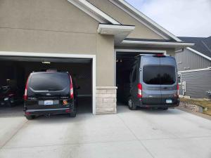 Two Class B campervans entering a residential garage at Siesta Hills, illustrating the community’s larger garage design that accommodates taller vehicles and HOA-friendly storage.