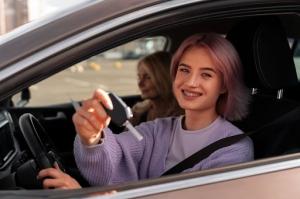 Teen driver holding car keys during a practice session, representing California teens completing DMV-approved driver-education requirements.