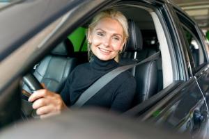 Smiling Ohio driver sitting in a car while preparing for state-approved online driver-education requirements.