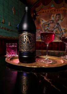 Revolution Apothecary Passion Punch bottle on a table, winner of a 100-point score.