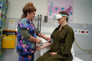 A pregnant patient explores a virtual world while being supported by her nurse