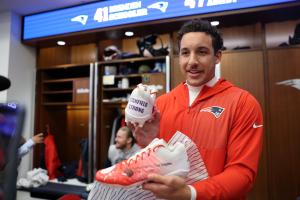 Julian Ashby holds custom red and purple cleats featuring National Blood Clot Alliance logo and “Stanfield Strong,” created for the NFL’s My Cause My Cleats campaign.