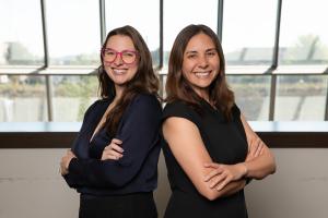 FMVS leaders Laura Renner and Erin Close stand back to back, smiling confidently, symbolizing a leadership transition at Freedom Makers Virtual Services