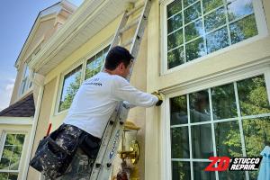 ZD Stucco Repair team member removes old caulking