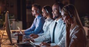 CX team working in an office with computers and headphones