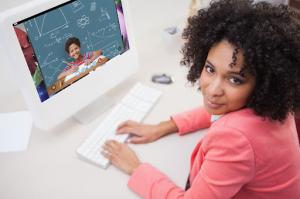 Woman sitting at a desktop computer studying through an online learning platform, representing flexible self-paced education.