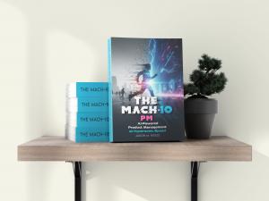 The MACH-10 PM hardcover displayed on a minimal white shelf beside a small plant and candles.