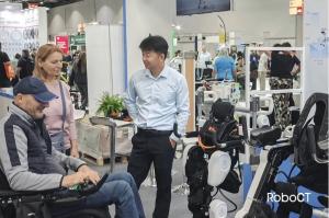 RoboCT representative demonstrates paediatric, adult rehab, and lightweight assistive exoskeletons to clinicians and visitors at the REHACARE booth.