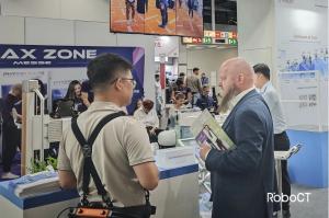 RoboCT specialist explains paediatric, adult rehab, and lightweight assistive exoskeletons to clinicians and visitors at the REHACARE booth.