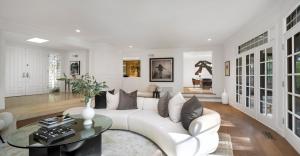 Luxury living room featuring sculptural furnishings, panoramic French doors, and serene garden outlooks.