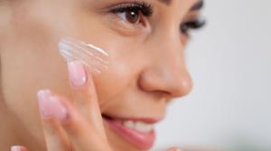 A Sego Lily Skincare customer applies the tallow butter made with all natural fragrances to her face.