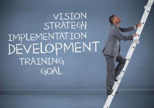 Man climbing a ladder toward words like vision, strategy, implementation, development, and goal, symbolizing personal growth and self-improvement progress.