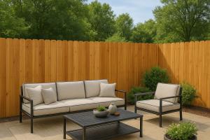 Cedar privacy fence behind metal outdoor furniture in a landscaped Louisiana backyard.