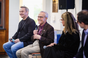 Four panelists seated on stage at Menlo College’s Institute of AI and Sustainability. From left to right: Dr. Jonathan Reichental, David Epstein (speaking into a handheld microphone), Dr. Sonia Saheb, and Dr. Dariush Rafinejad.