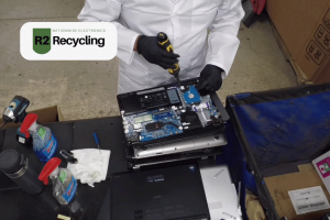 Worker dismantling a laptop