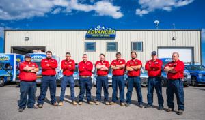 HVAC service team standing in front of company building and service trucks.
