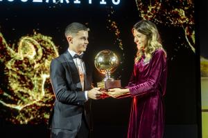 Christos Mouzakitis receiving his trophy on stage with a woman