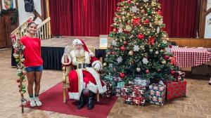 Santa Claus posing with children and families at Christmas Market Miami holiday event.