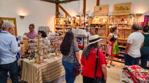 Vendor booths with shoppers browsing handmade Christmas products at Christmas Market Miami.