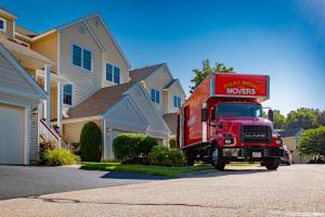 Red Philip P. Massad Movers truck parked in front of suburban homes during a residential move in Massachusetts