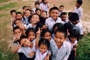Group of children smiling and standing outdoors while participating in a program supported by B1G1.
