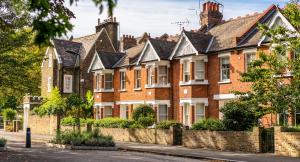 A residential street in the UK featuring a row of uniform brick terraced houses, representing common UK property stock currently facing sale due to rising tax and mortgage pressures.