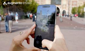 A person holds a smartphone showing an augmented reality installation in front of the Rijksmuseum in Amsterdam. The AR artwork appears as a pixelated 3D figure with a question mark above it. The Augmento Studio logo is displayed in the top corner.