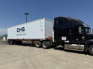 A CHS-branded shipping container rental loaded onto a truck.