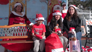 A family taking photos with Santa Claus and Mrs. Santa Claus at LATLC's Comfort & Joy, "A Miracle on 34th Street" in Los Angeles