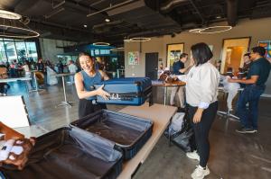 Smiling volunteers packing suitcases