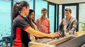 Robotimize team members demonstrating Synslai mirror therapy system features to international healthcare delegates at showroom