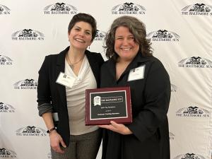 Sandy, Manager of Business Development, and Maili, People Ops and Culture Lead, pose with ITS’s Baltimore Sun Top Workplaces award.