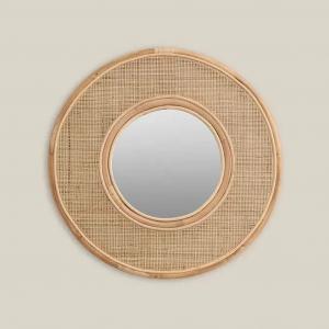 Round rattan mirror hanging in Dubai balcony space