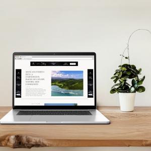 A laptop displays the Branded Living homepage. Branded Living is the definitive platform for branded residences worldwide.