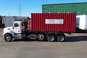 A sign that says EACR Inc on a red shipping container on a truck
