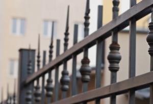 Steel fence with a home in the background.