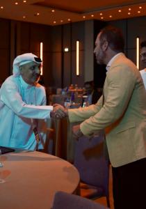 Nick Ayala shaking hands with a UAE business leader at a conference in Dubai during The Wealth Circle’s global expansion.