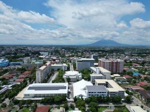 A large rooftop solar power installation at Holy Angel University in Angeles City, built by Solaren, showing wide photovoltaic arrays across multiple buildings.