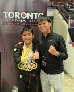 Eli Cooper displays his 5 medals with coach Ben Clarke at the Toronto International Tournament of Martial Arts Championships