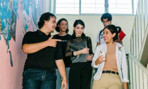 University students chatting happily as they walk down a staircase.