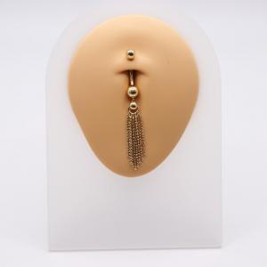 Gold belly button ring with dangling chain tassels on display