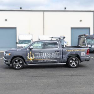A Trident Contracting, Inc. service truck wrapped in company branding, displaying the logo, website, and contractor license information.