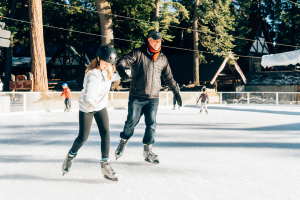 Father and daughter ice skating on the Silver Bells Arena at SkyPark at Santa's Village