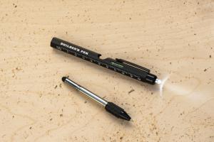 Black 9-in-1 Builder’s Pen on a wood surface with its detachable mini multi-tool laid beside it, showing the bubble level, ruler markings, stylus tip, and screwdriver insert.