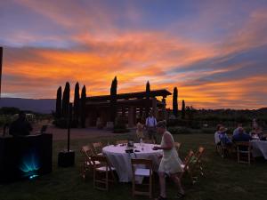 Stunning sunset over Alcantara Vineyards during an outdoor wedding reception with guests seated at tables on the lawn.